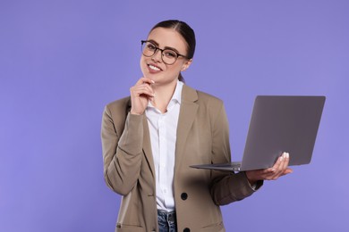 Photo of Happy woman in glasses with laptop on violet background