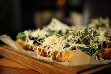 Photo of Delicious bruschettas with beef and cheese on wooden table, closeup