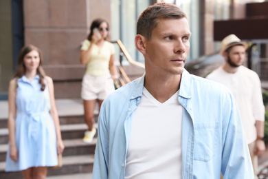 Handsome man walking on modern city street