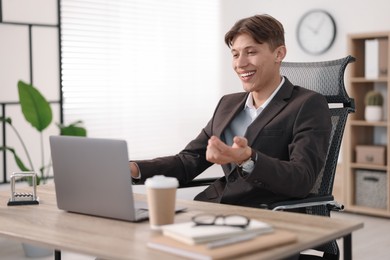 Man using video chat during webinar at wooden table in office