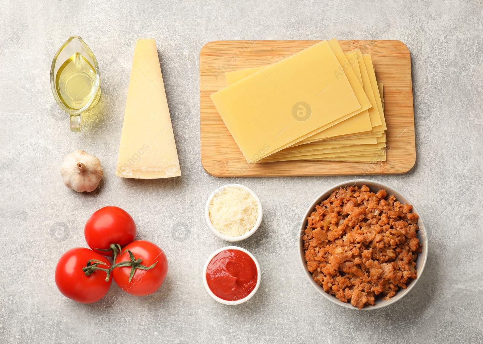 Photo of Flat lay composition with products for cooking lasagna on grey textured table