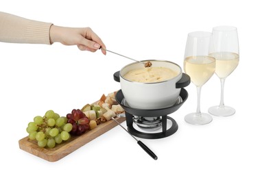 Photo of Woman dipping walnut into fondue pot with melted cheese on white background, closeup