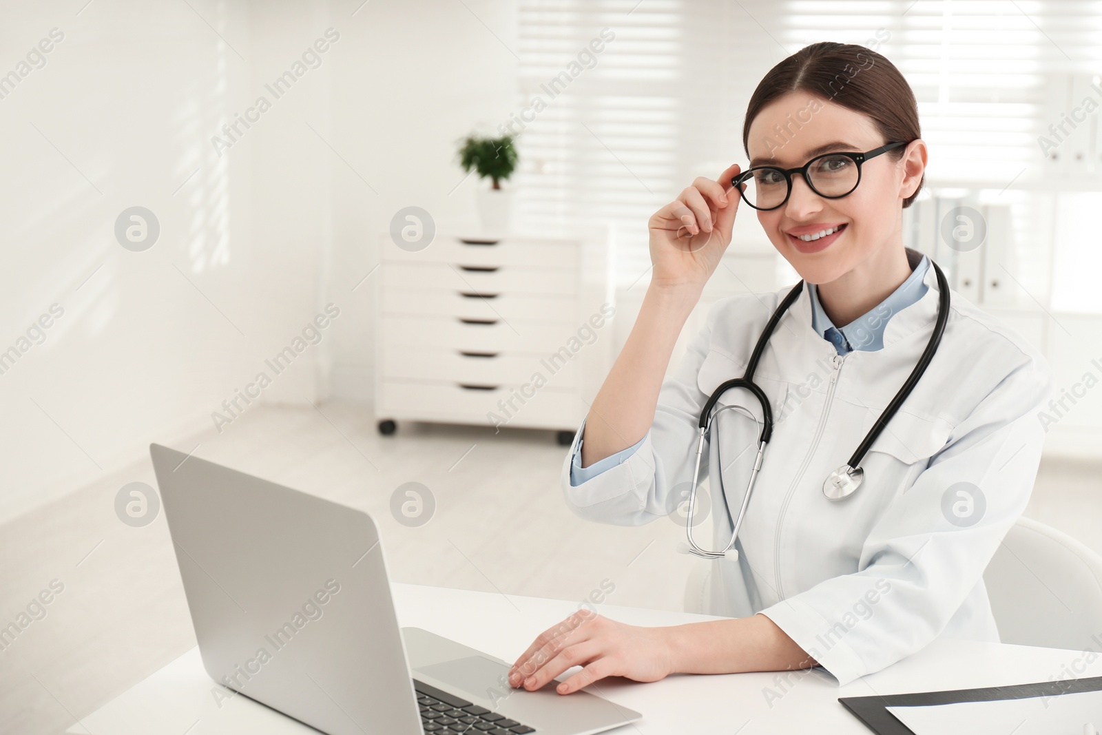 Photo of Portrait of young female doctor in white coat at workplace