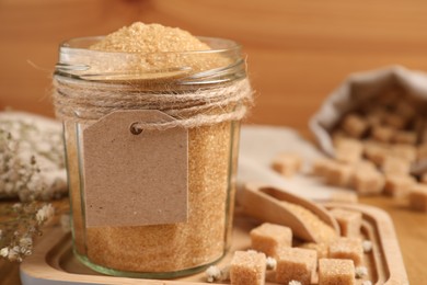 Photo of Jar with brown sugar on wooden table, closeup. Space for text