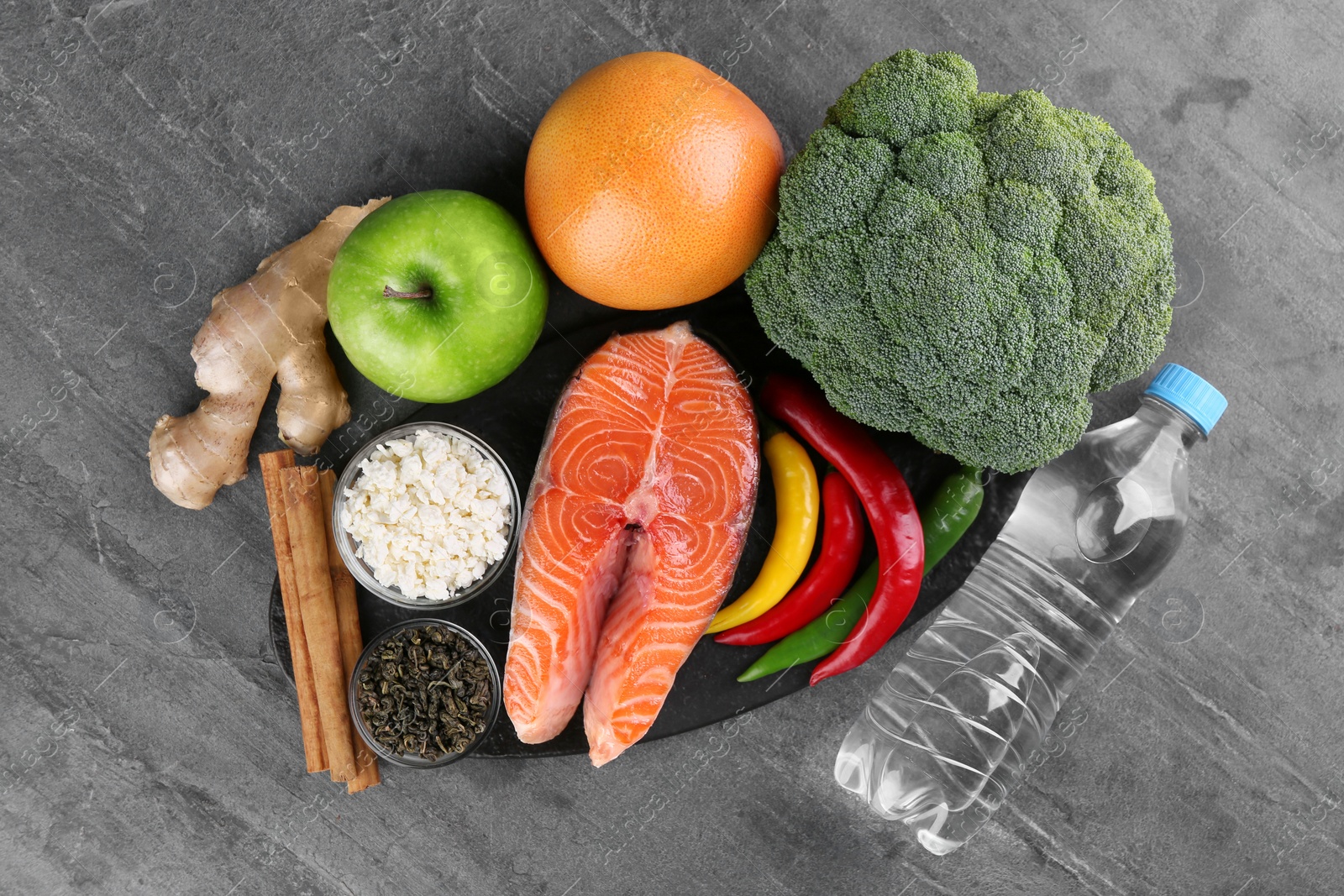 Photo of Metabolism. Different food products on grey table, flat lay