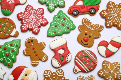 Different tasty Christmas cookies on white background, flat lay