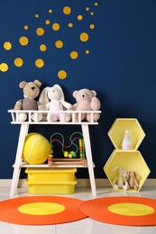 Different toys near blue wall in child room. Interior design