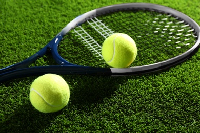 Photo of Tennis racket and balls on green grass. Sports equipment