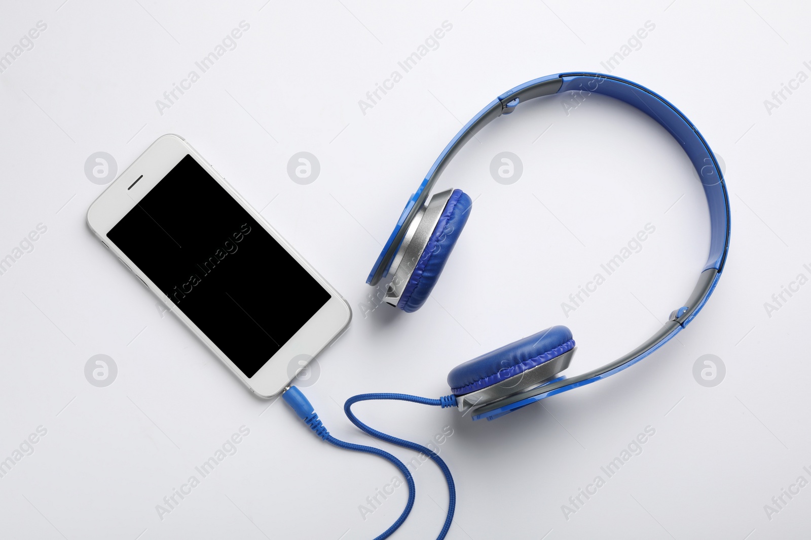 Photo of Stylish headphones and modern phone on white background, top view. Space for text