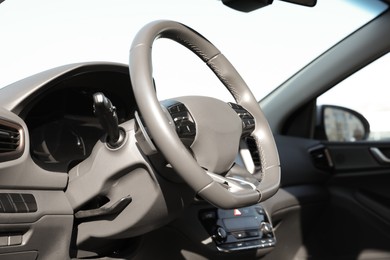 Photo of Black steering wheel and dashboard in modern car