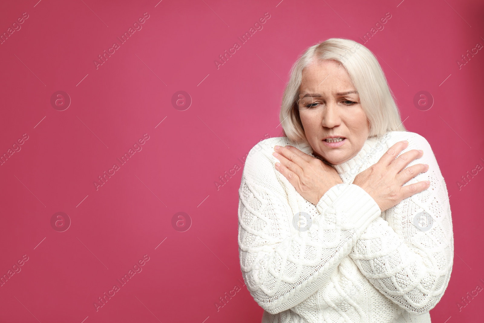 Image of Mature woman suffering from fever on pink background, space for text. Cold symptoms