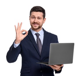 Handsome bearded businessman in suit with laptop showing OK gesture on white background