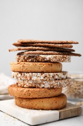 Photo of Stack of rye crispbreads, rice cakes and rusks on table, closeup