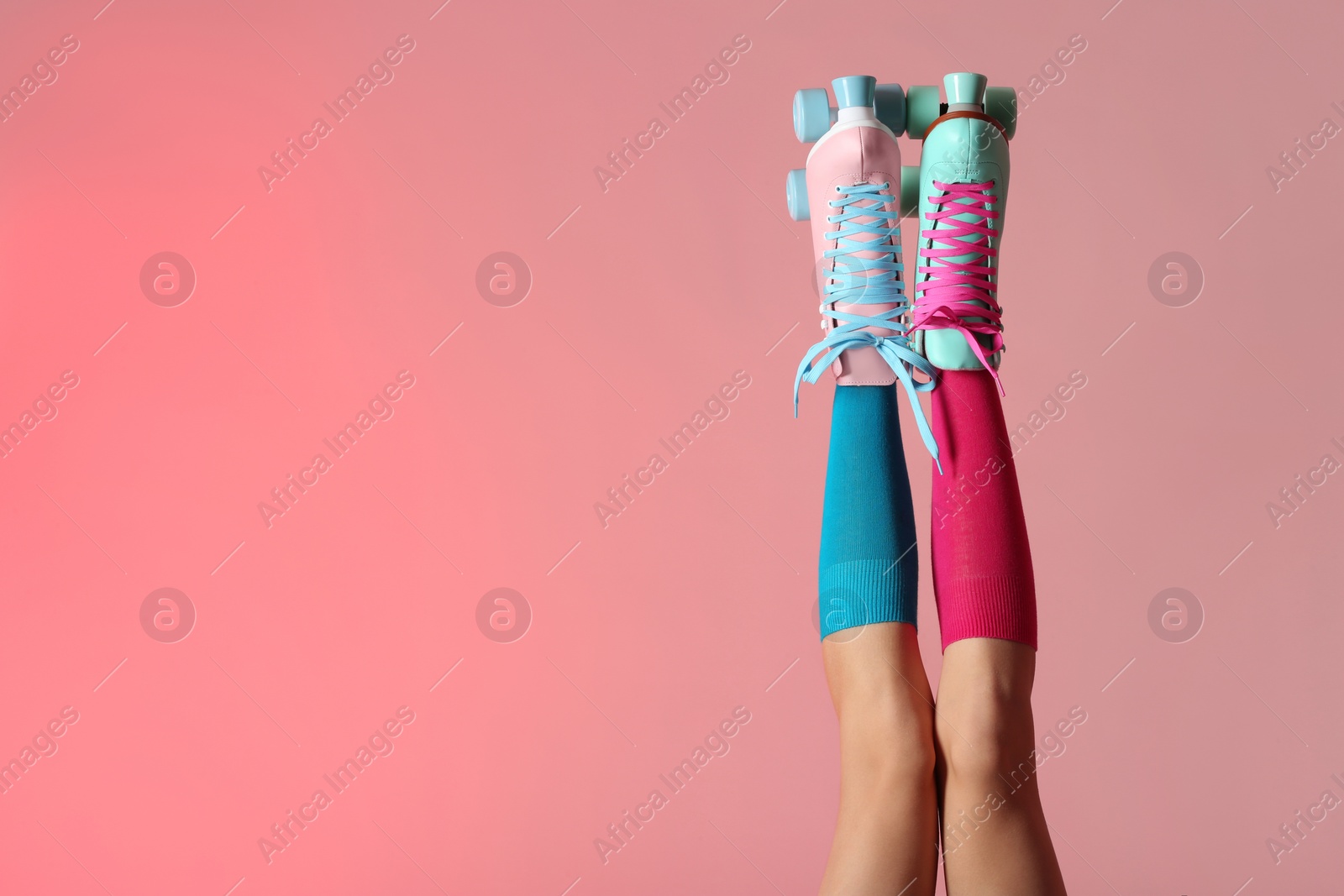 Photo of Woman with vintage roller skates on color background, closeup. Space for text