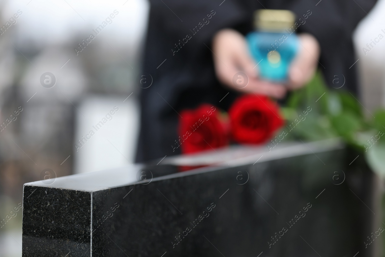 Photo of Black granite tombstone outdoors, closeup. Funeral ceremony