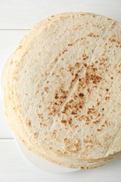 Photo of Stack of tasty homemade tortillas on white wooden table, top view