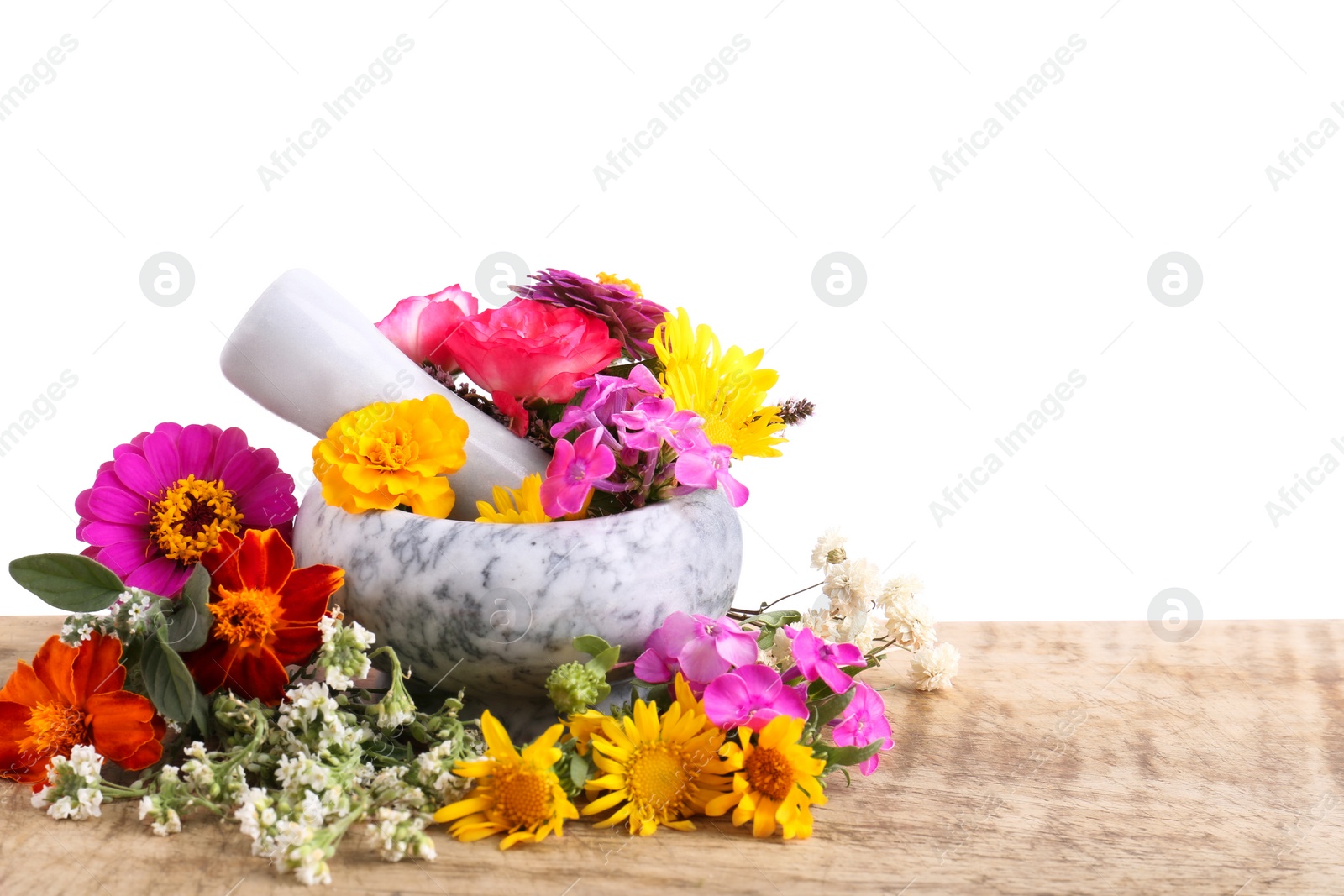 Photo of Marble mortar, pestle and different flowers on wooden table against white background. Space for text