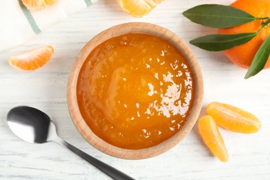 Flat lay composition with tasty tangerine jam on white wooden table