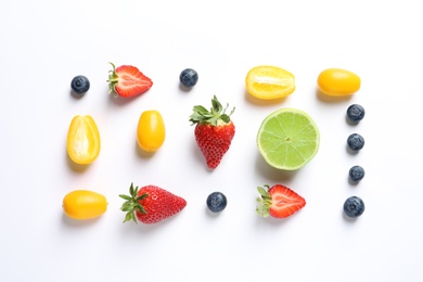 Fresh fruits and berries on white background, top view