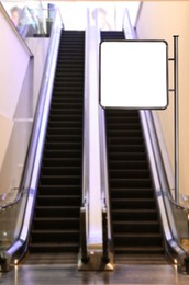 Image of Blank advertising board near escalators in shopping mall. Space for text