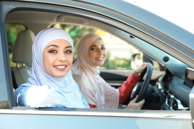 Photo of Muslim woman sitting near female driver in car