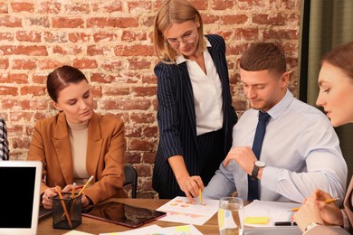 Photo of Businesswoman having meeting with her employees in office. Lady boss