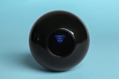 Photo of Magic eight ball with prediction Can't Say Now on light blue background