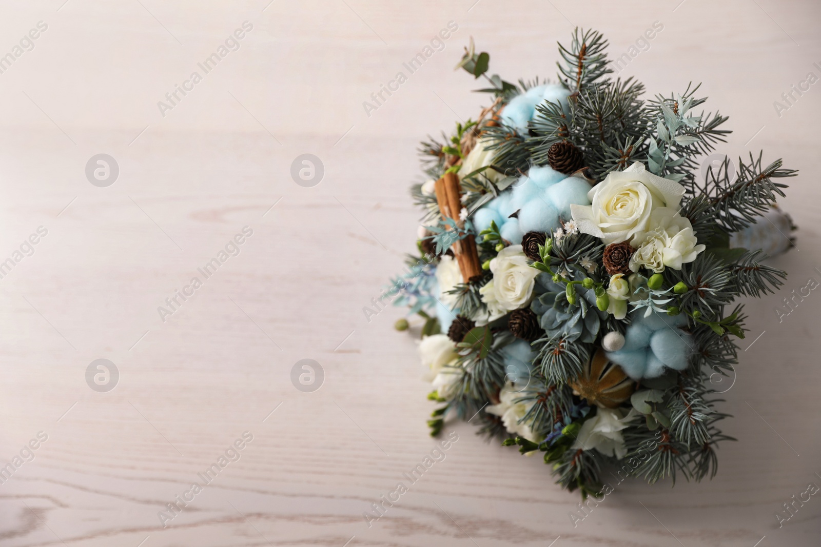 Photo of Beautiful wedding winter bouquet on white wooden table, top view. Space for text