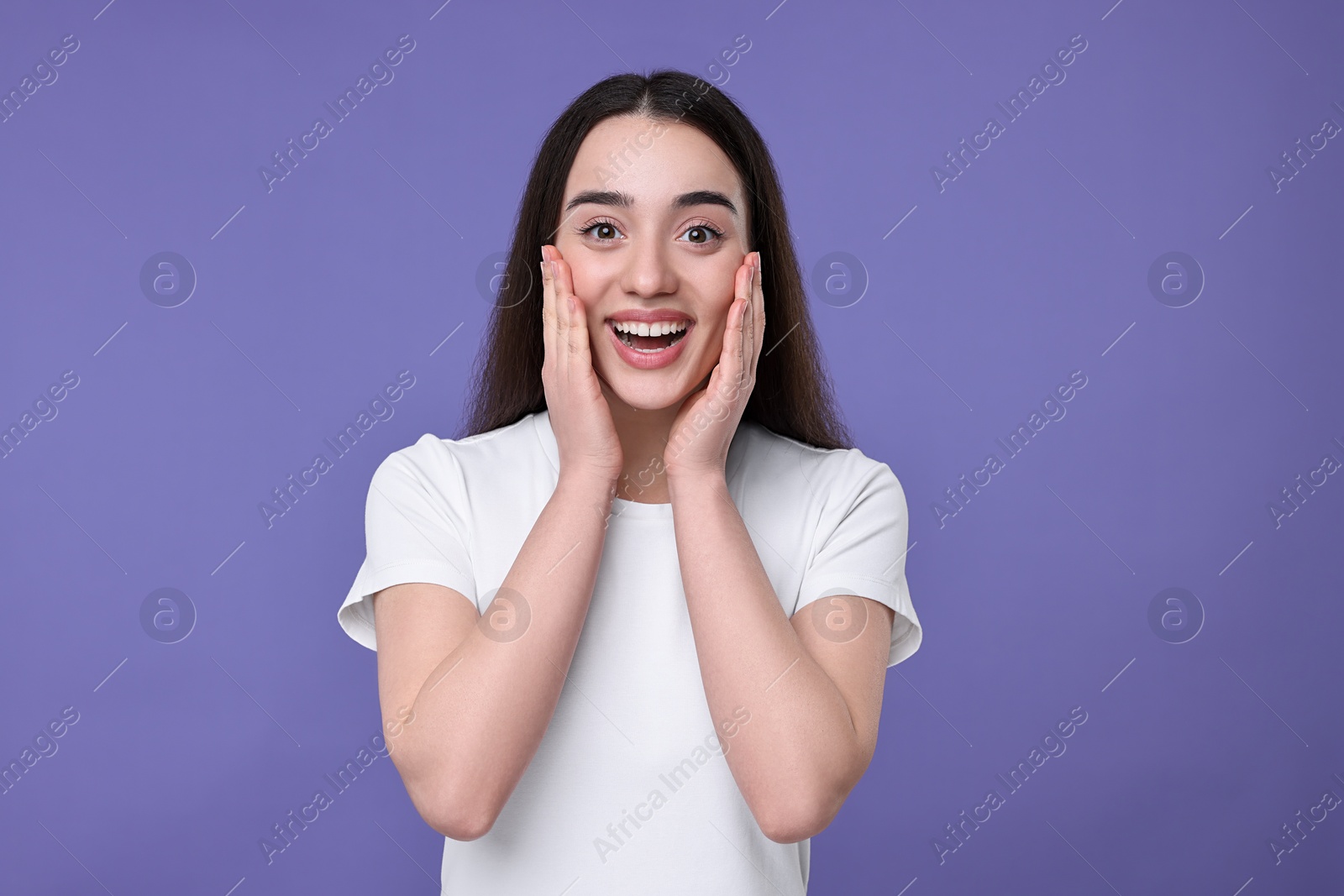 Photo of Portrait of happy surprised woman on violet background