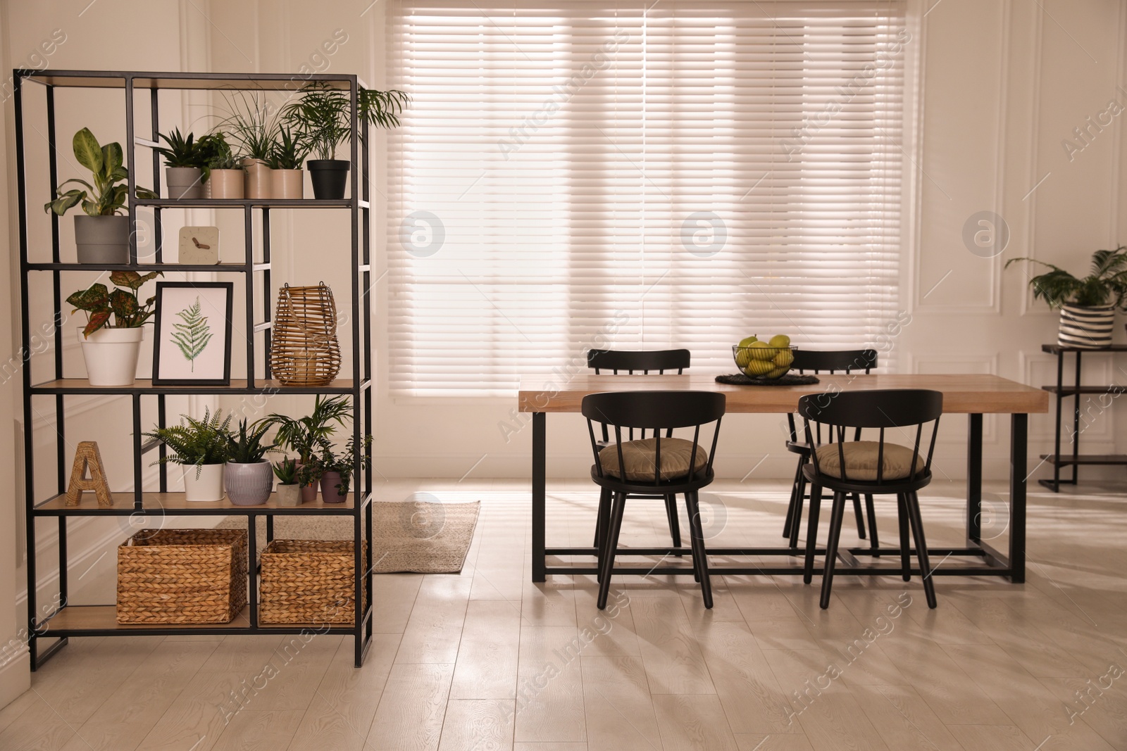 Photo of Modern dining table with chairs and shelving unit in room. Interior design