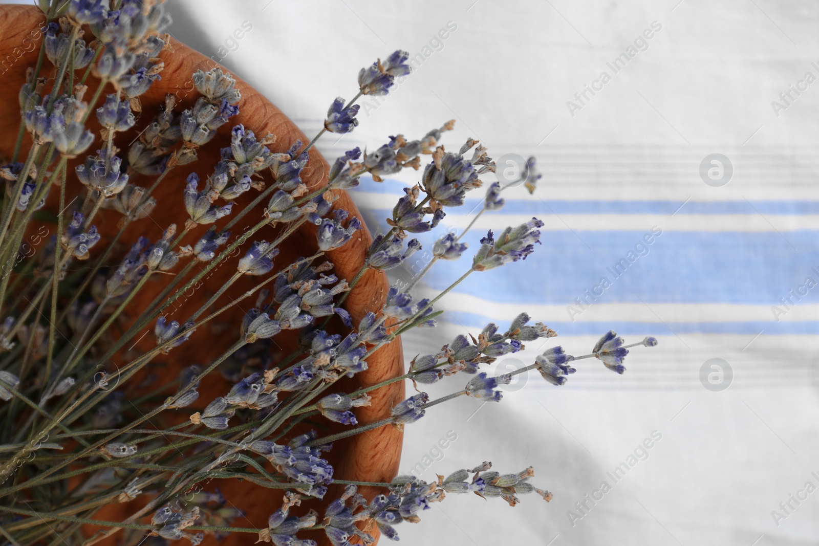 Photo of Bowl with beautiful lavender flowers on tablecloth, top view. Space for text