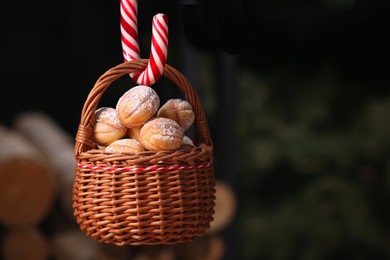 Photo of Wicker basket with delicious nut shaped cookies on blurred background. Space for text