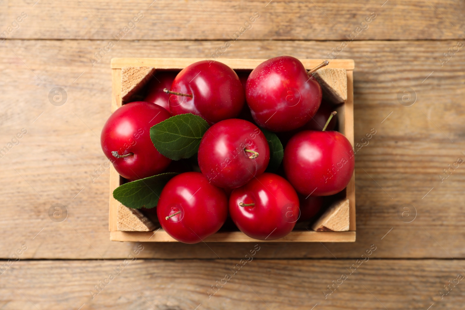 Photo of Fresh ripe cherry plums on wooden table, top view