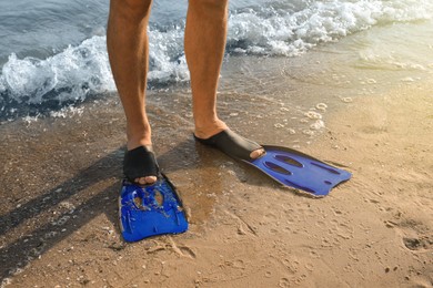 Photo of Man in flippers on sandy beach, closeup