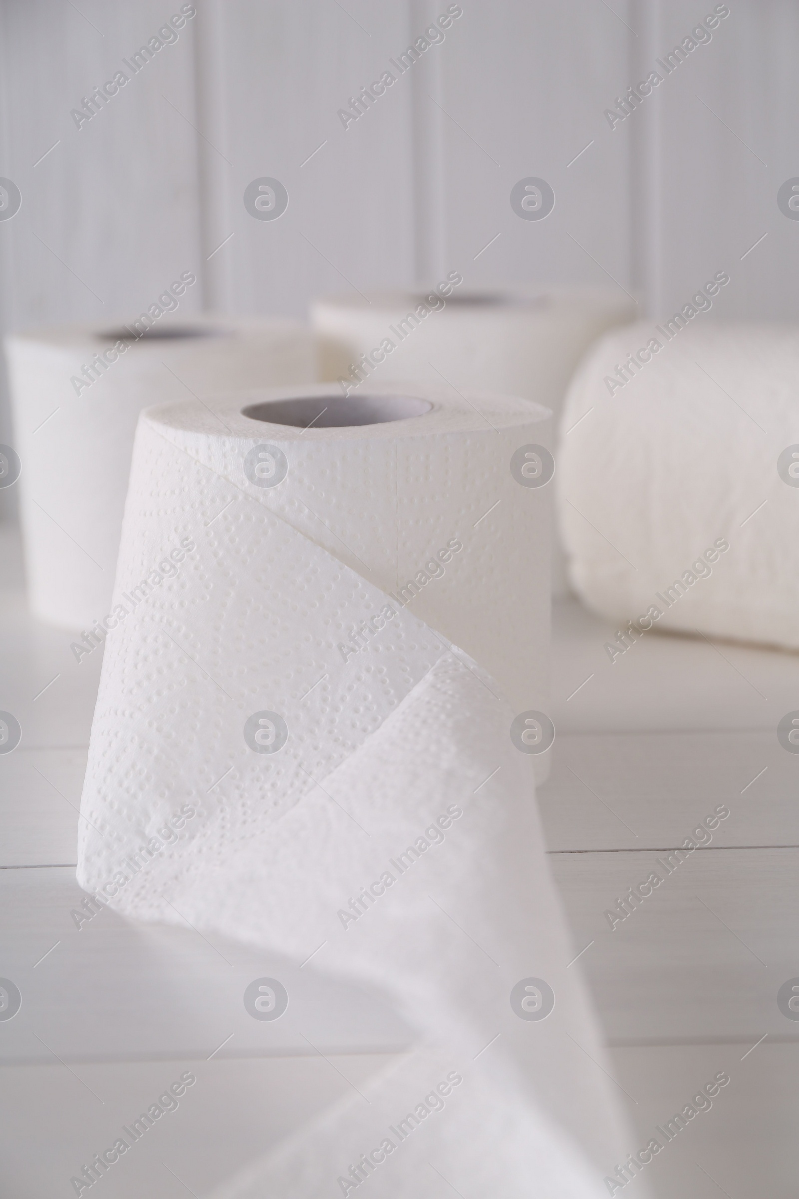 Photo of Soft toilet paper rolls on white wooden table