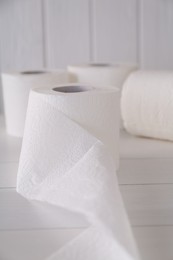 Photo of Soft toilet paper rolls on white wooden table