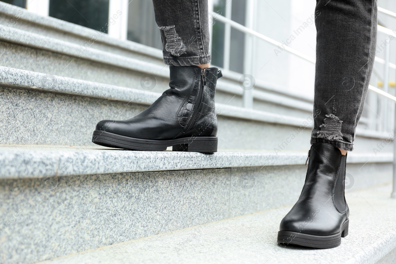 Photo of Woman in stylish boots on stairs outdoors, closeup