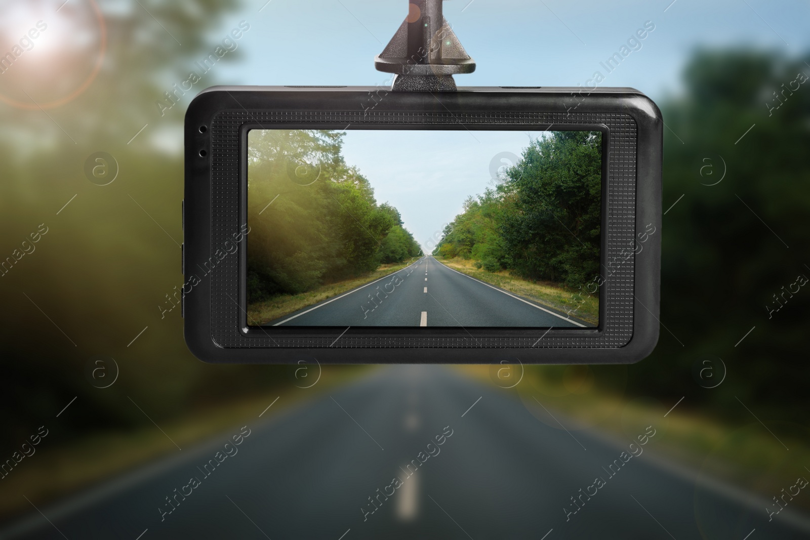 Image of Modern dashboard camera mounted in car, view of road during driving