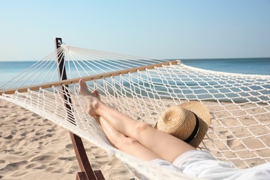 Young woman relaxing in hammock on beach