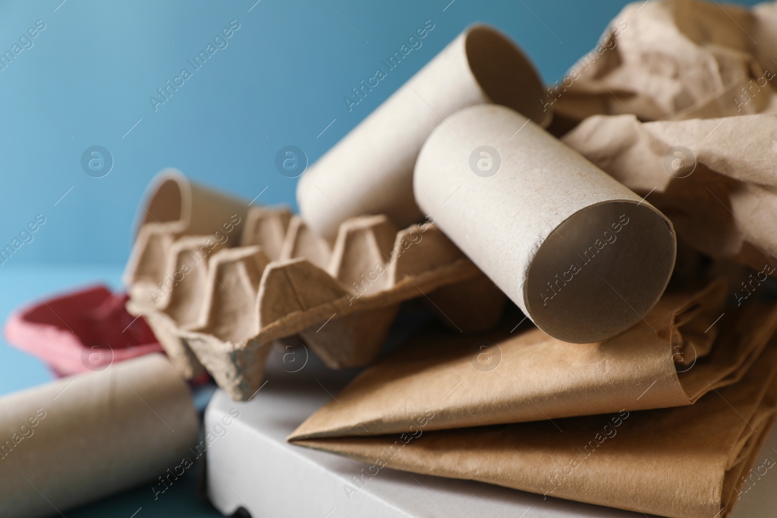 Photo of Different waste paper on light blue background, closeup