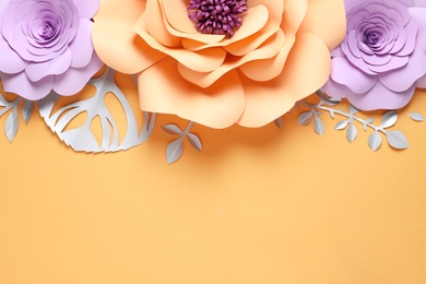 Different beautiful flowers and branches made of paper on orange background, flat lay. Space for text