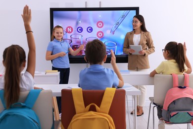 Photo of Teacher and pupil using interactive board in classroom during lesson