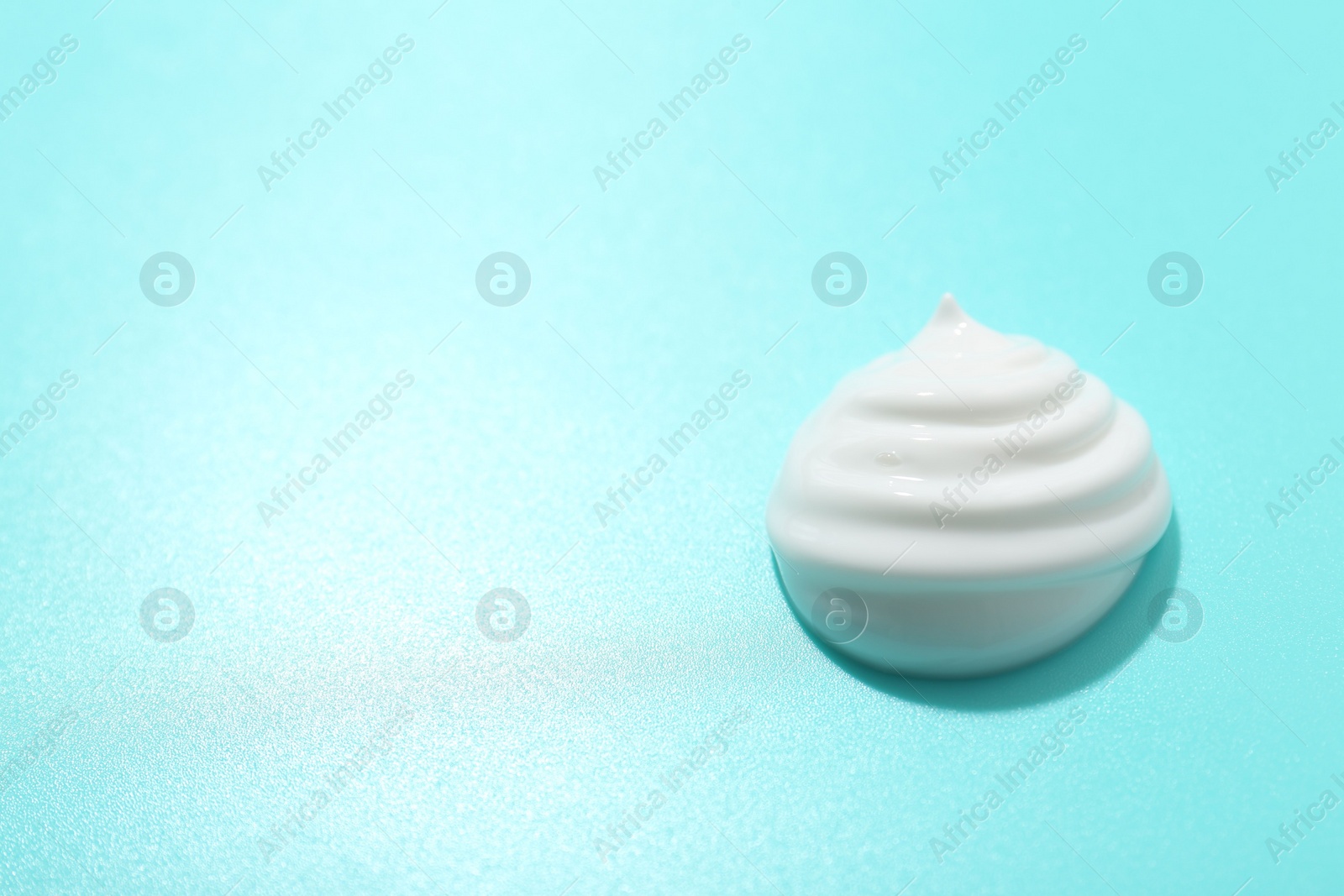 Photo of Drop of face cream on light blue background. Space for text