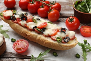 Tasty pizza toast and ingredients on wooden table, closeup