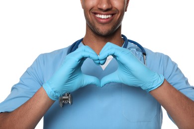 Photo of Doctor or medical assistant (male nurse) in uniform making heart shape with hands on white background, closeup
