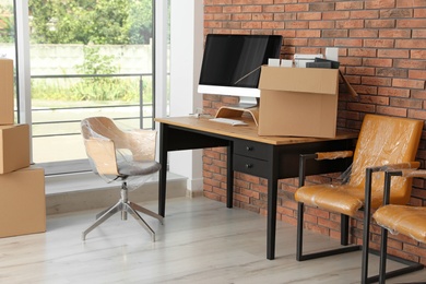 Interior of modern office with packed belongings. Moving service