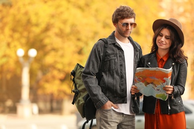 Couple of travelers with map on city street