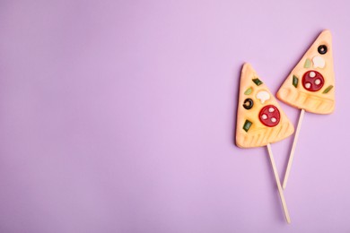 Photo of Pizza shaped lollipops on violet background, flat lay. Space for text