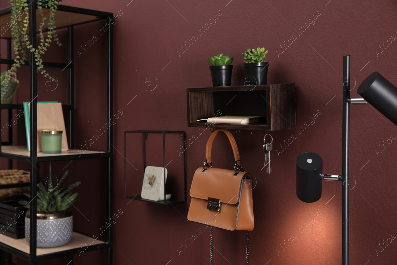 Photo of Wooden key holder with bag and houseplants on wall in room