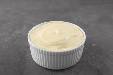 Photo of Fresh mayonnaise sauce in bowl on grey table